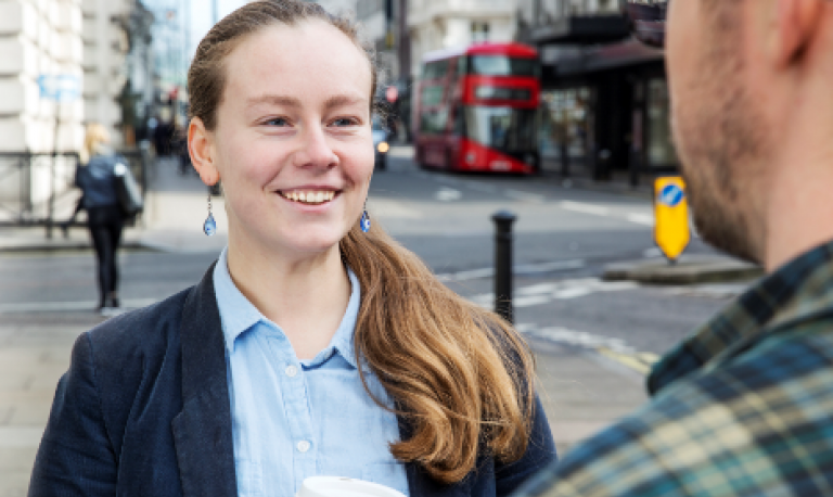 a woman talking to a man on the street